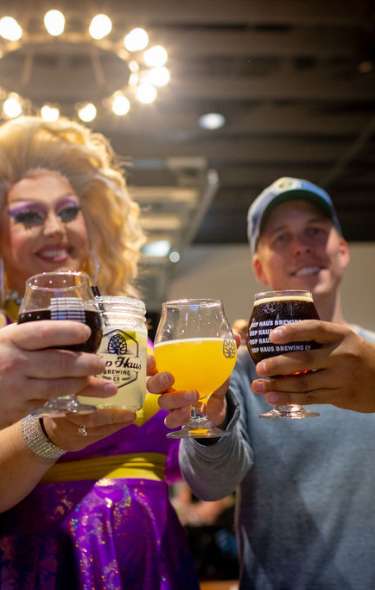 Three men and a drag queen cheers their drinks at Hop Haus Brewing.