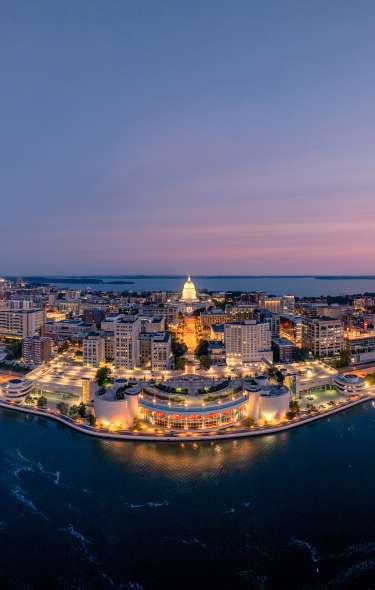 A wide-shot image of the Madison skyline and isthmus during sunset.