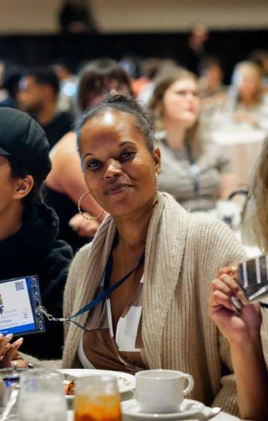 Three Black women sitting at a banquet table at a mental health conference in Madison