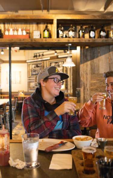 Two white women enjoy beers at the bar at Lone Girl Brewing Company