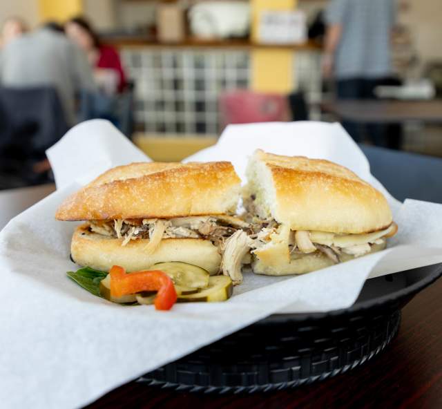 Delicious sandwich cut in half with cafe in the background