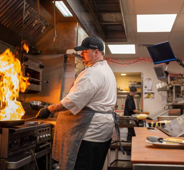 chef cooking with a pan on fire at a restaurant in rapid city, sd