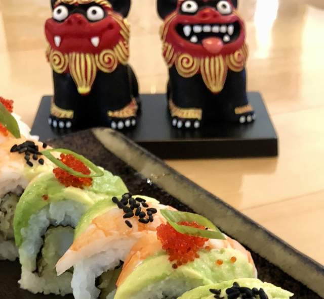 Close up of sushi rolls with Japanese dragons in the background