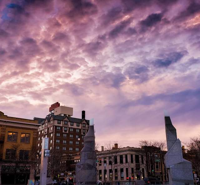 Purple sunset over downtown with fluffy clouds