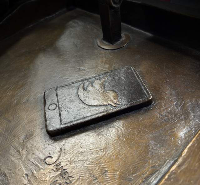 Bronze phone with a twitter logo on a bronze podium