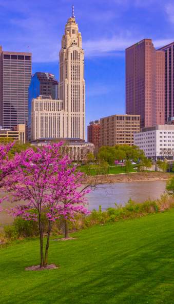 Columbus skyline along the Scioto Mile during spring with blooming pink trees
