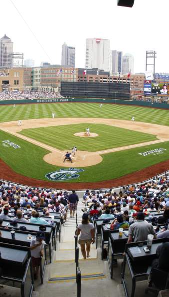 Clippers baseball game at Huntington Park baseball with crowd in seats and skyline in background under blue sky