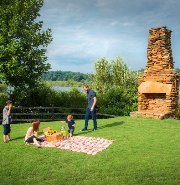 A Family having a picnic on the grass at Morgan Falls Overlook Park.
