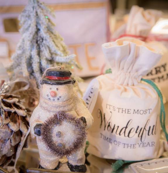 Holiday table display at Kudzu & Company featuring a snowman and pinecone