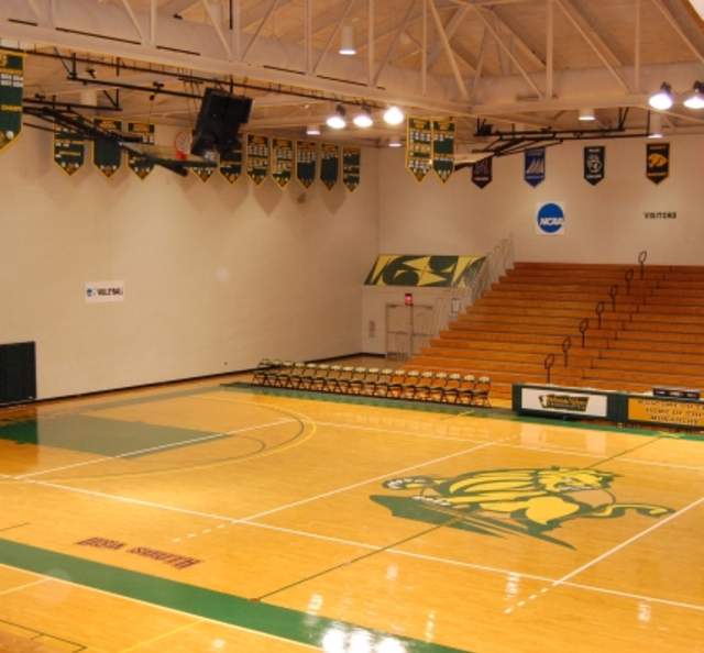 Indoor gymnasium at Riddle Center on Methodist University campus with basketball court, seating, and championship banners