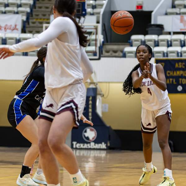 Photo of girl bringing the basketball up the court on a fast break to score.