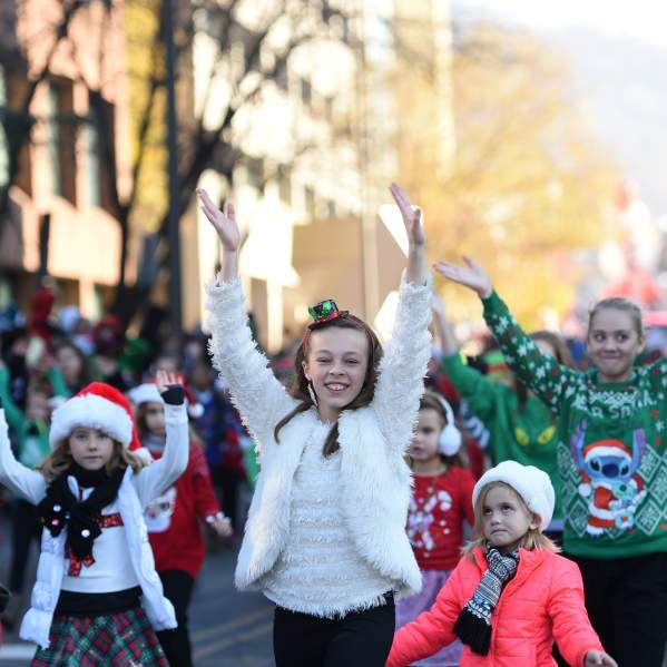 Children dancing in the holiday parade wearing festive outfits