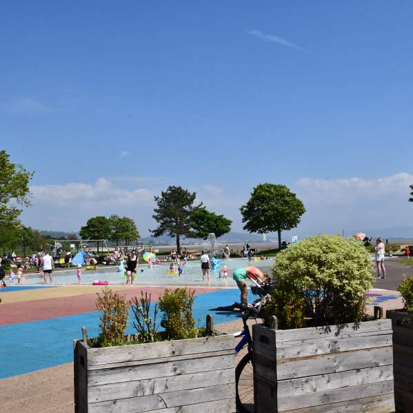 families playing in the water in the summer sun at blackpill lido