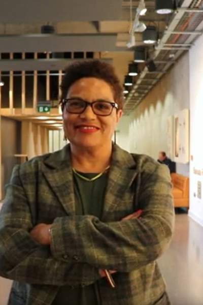 Poet Jackie Kay stood smiling in a conference area