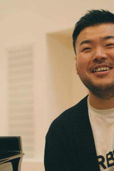Leo Yu smiling in front of a piano