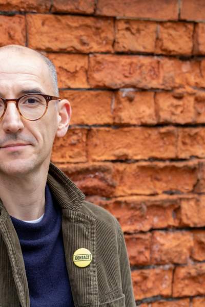 Matt Fenton Director of Contact Theatre stood against brick wall