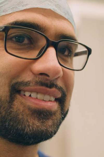 Dr Naseer Ahmad close up smiling in scrubs