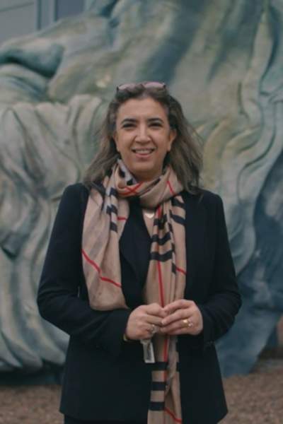 Professor Samia Nefti-Meziani  stood in front of a sculpture in Manchester