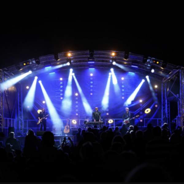 stage lit up in blue with spotlights musicians performing