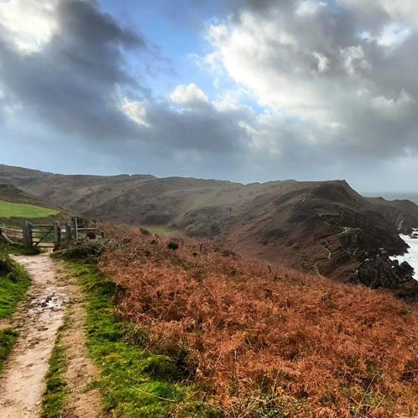 coast of Devon in Autumn, stormy clouds and view of a coastal walking path