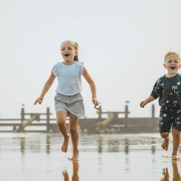 Two children running along the beach in Hornsea