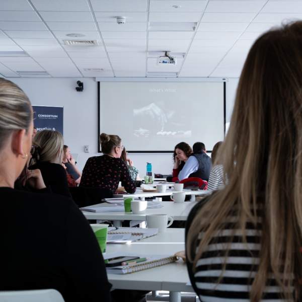 participants of a business workshop, facing the front screen.