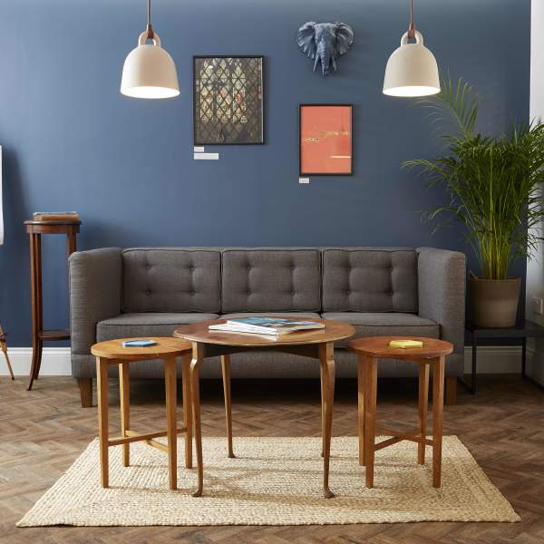 Grey Sofa with 3 small tables, easel, Hanging modern lights. Navy feature wall.