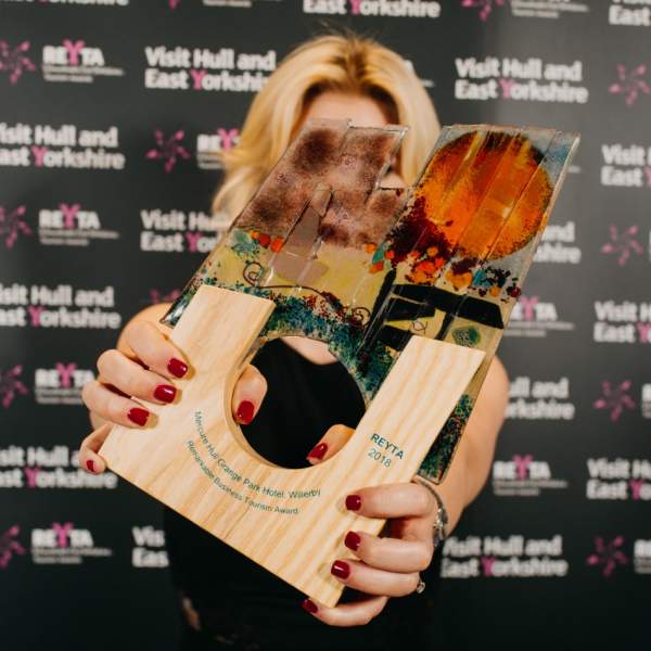 a winner holding the 2028 trophy in front of her