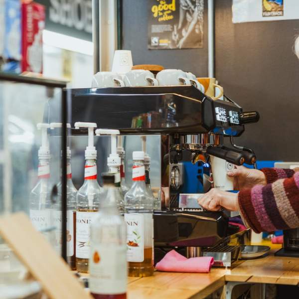 a barista making coffee at Trinity Market