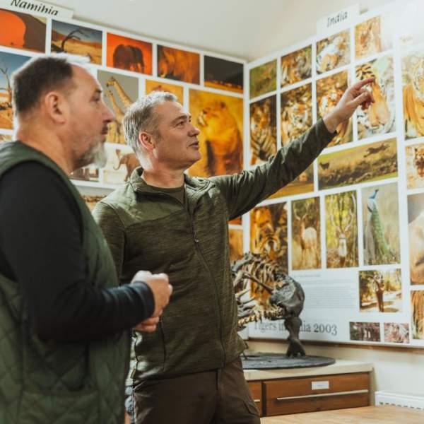 Guide and visitor at Robert Fuller Gallery admiring the wildlife photograph which is lining every corner of the walls
