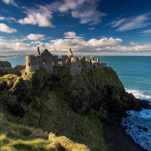 Medieval Dunluce Castle with blue skies.