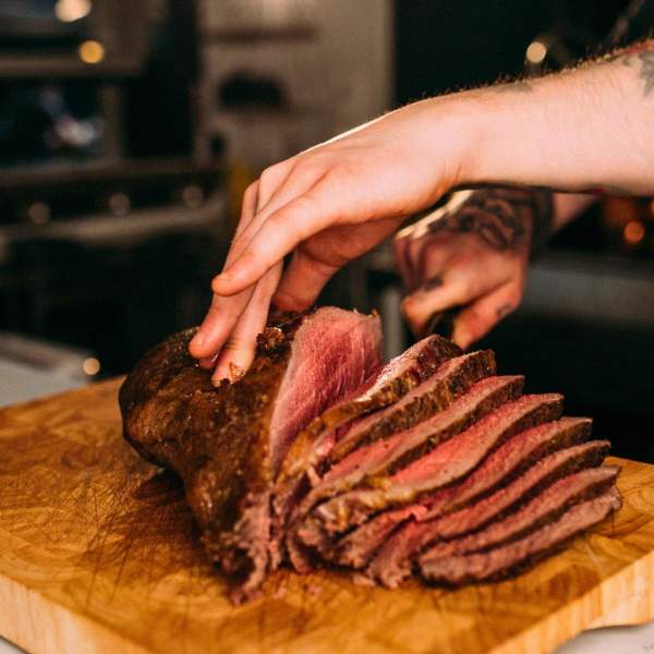 A chef slicing a large piece of beef for Sunday Lunch