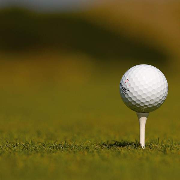 Image of a golf ball sitting on a tee at the P&O Golf tournament at Royal County Down Golf course