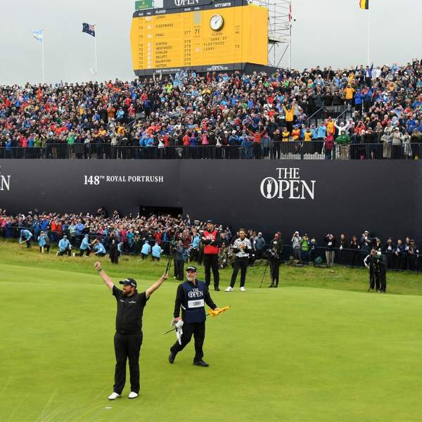 Golfer Shane Lowry celebrating his British Open win on the 18th green in front of a huge crowd