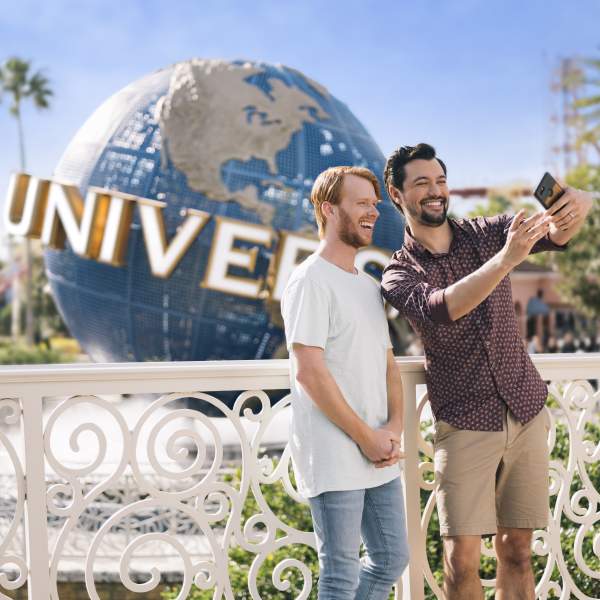 gay couple taking selfie at universal studios globe