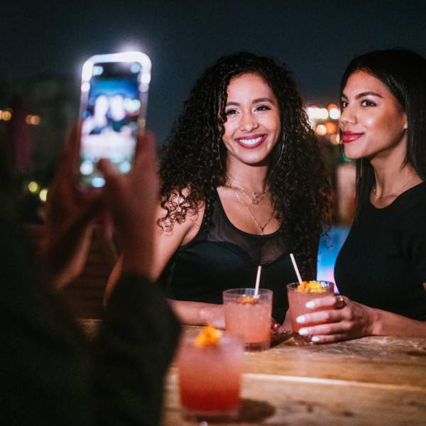 A woman takes a photo of two other women during a girls' night out in Orlando.