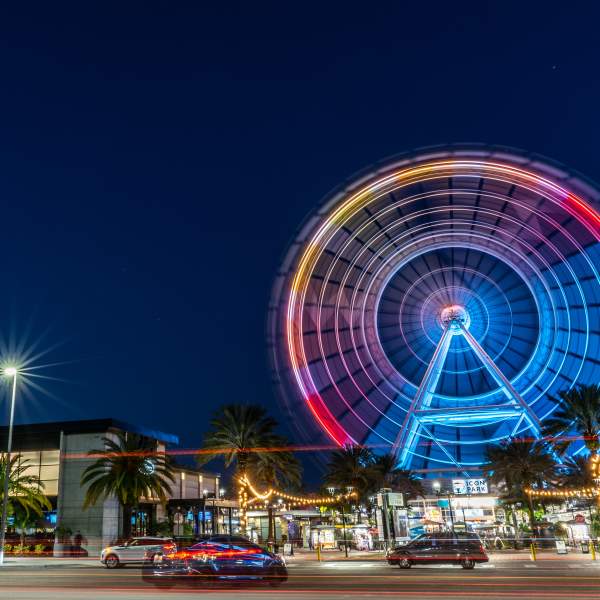Cars on street in front of The Wheel at night