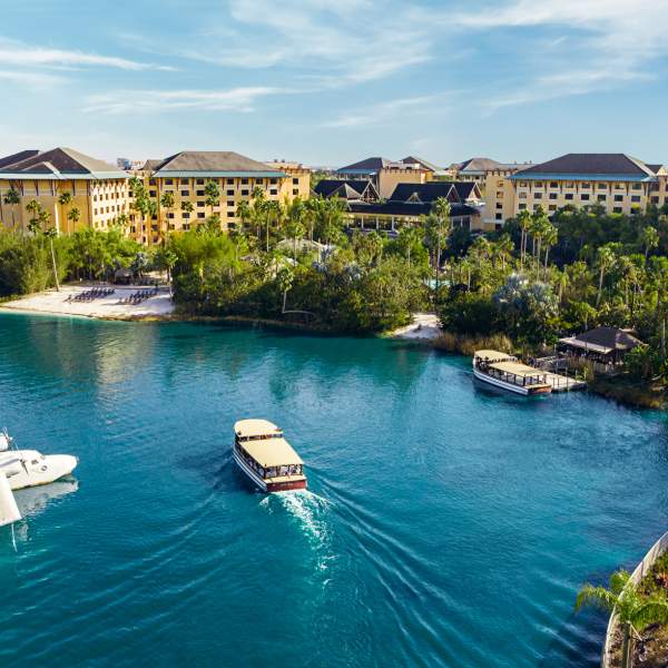 A water taxi floats through tranquil waters to Loews Royal Pacific Resort at Universal Orlando