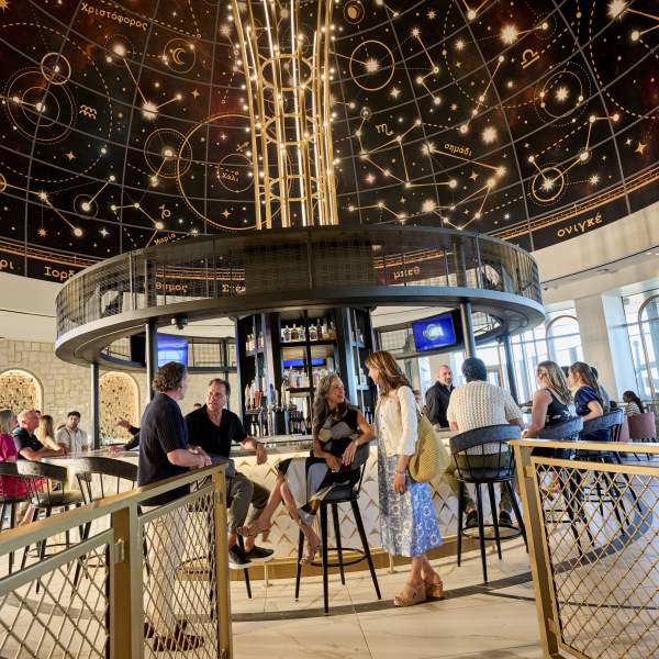 Interior of Bar Helios, featuring a domed, navy ceiling with celestial patterns and a circular central bar