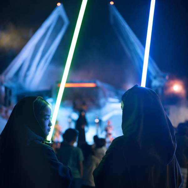 Sisters holding light sabers while facing Kylo Ren Star Wars: Galaxy's Edge at Disney's Hollywood Studios in the Walt Disney World Resort.