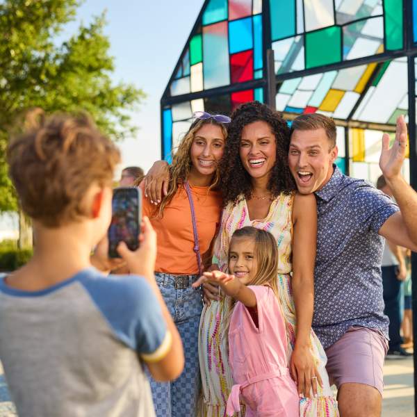 A family taking a silly photo in front of a colorful glass house in Lake Nona