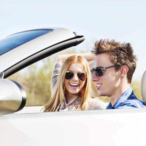 Young couple sitting in their car and enjoying in the road trip.