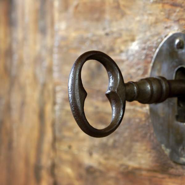 Closeup of an old keyhole with key on a wooden antique door