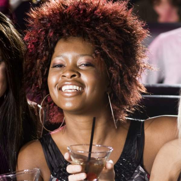 Three women hanging out at a bar, having a good time.