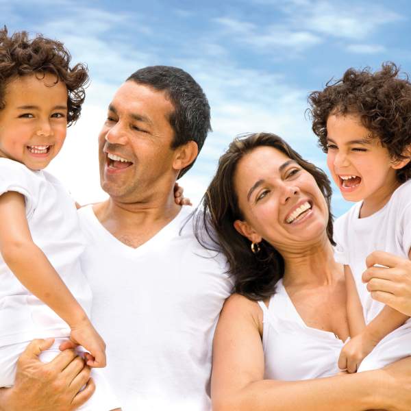 A happy family smiling outdoors while on vacation.