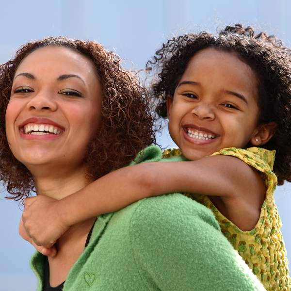 An African-American mother and daughter smiling