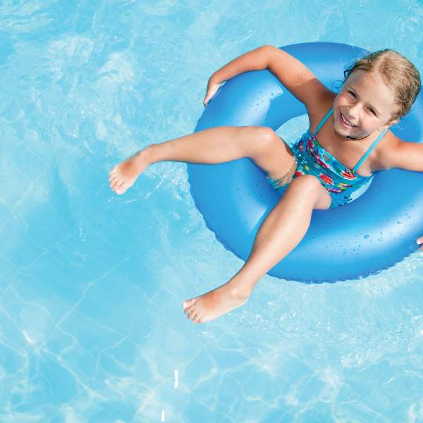 a girl floating on an inner tube in a swimming pool