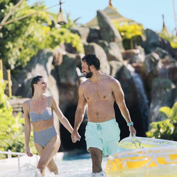 A couple walking out of the lazy river in Universal's Volcano Bay