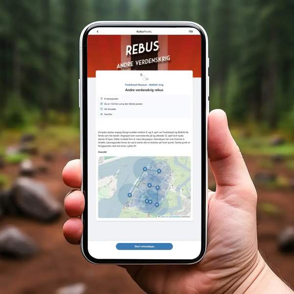 En person holder opp en mobil som viser KulturPunkter og en rebus om 2. verdenskrig.