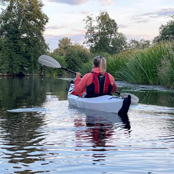 En kajakk som padler nedover en smal elv på jakt etter bever
